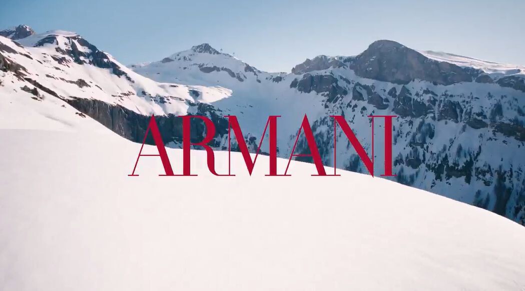 Cinematic Giorgio Armani winter holiday video featuring models in a snowy alpine resort setting, showcasing luxury Armani Beauty gift sets, lipsticks, and cosmetics amidst scenic mountain landscapes.