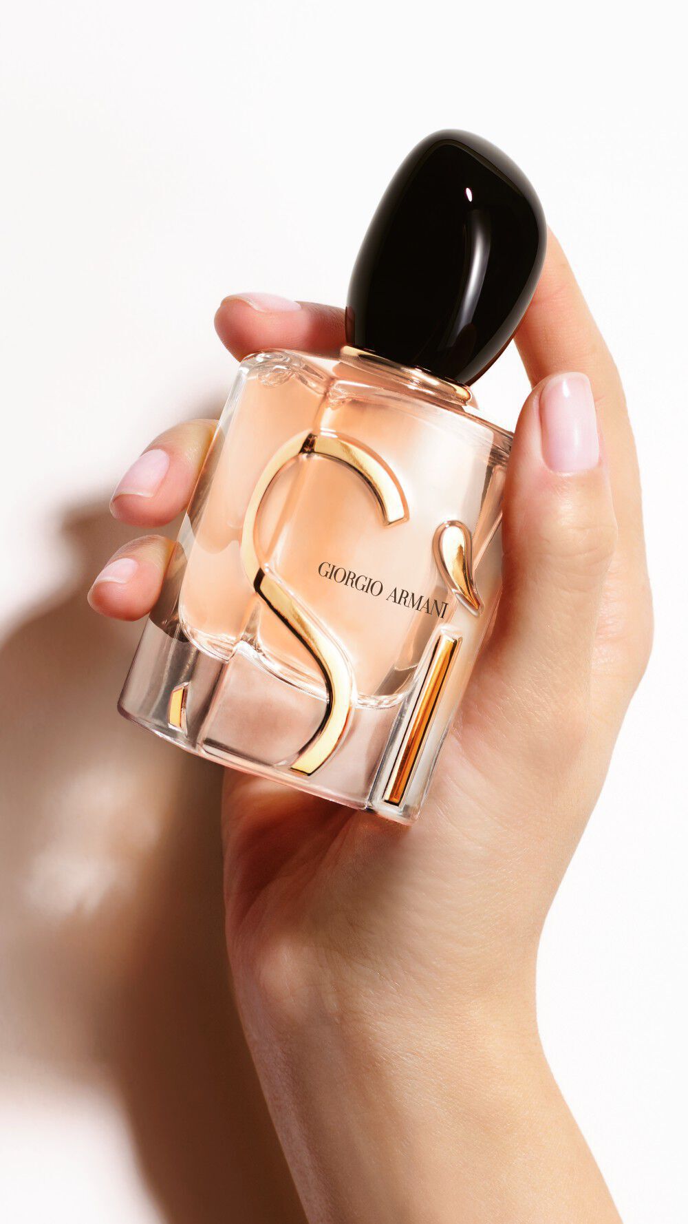 Een hand die een fles SI EAU DE PARFUM vasthoudt