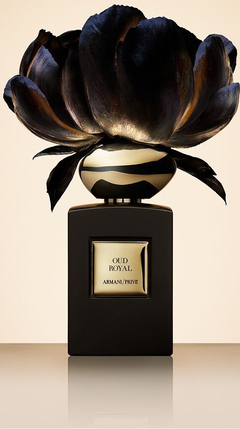 Armani/Prive Oud Royal: een diepzwarte flacon bekroond met een donkere bloem met gouden reflecties, die de koninklijke essentie van oud-hout en de sacrale verfijning van oosterse paleizen vangt.