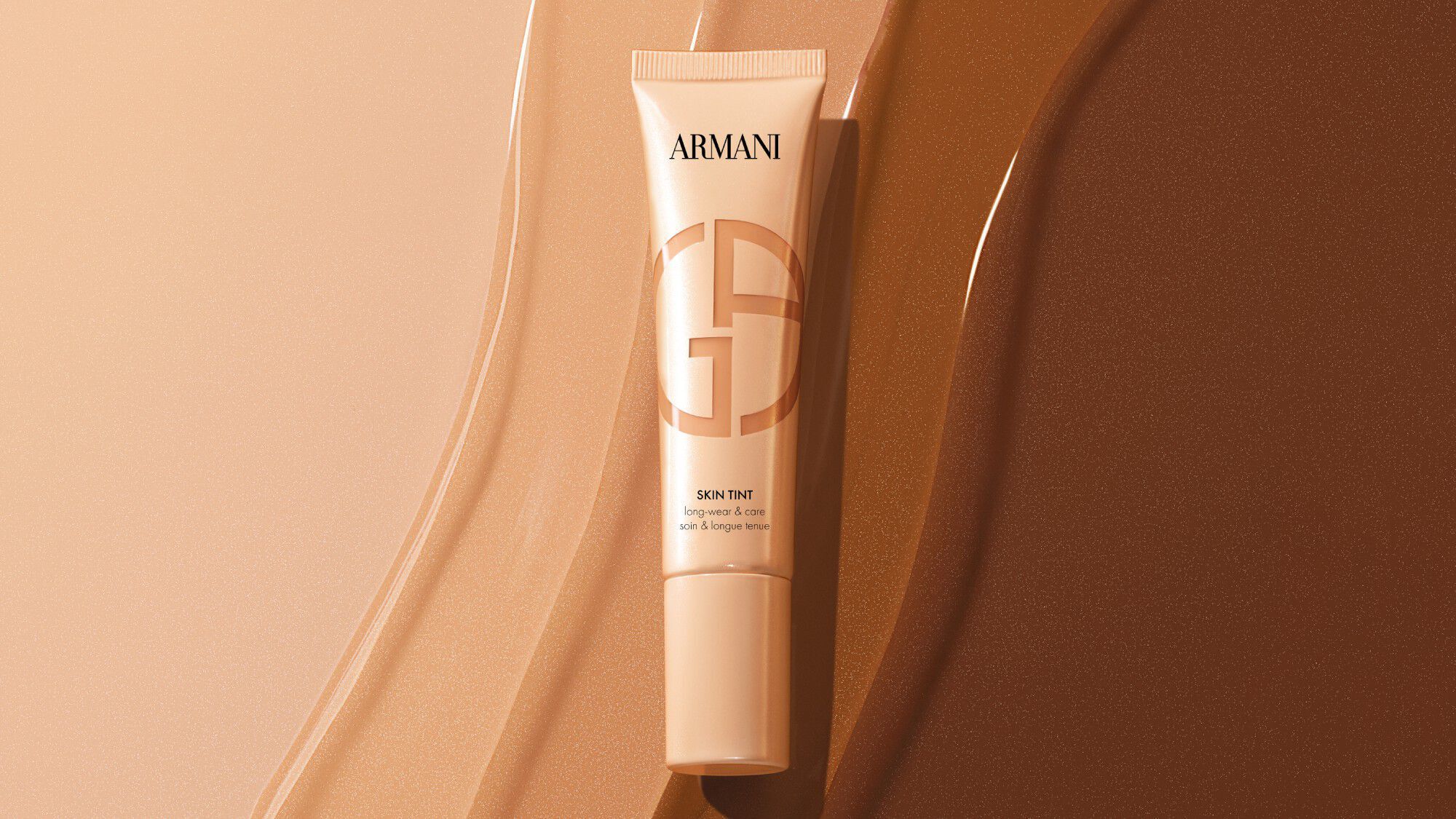 Armani Skin Tint tube op vloeibare foundation swatches in verschillende tinten.