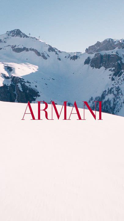 Cinematic Giorgio Armani winter holiday video featuring Madisin Rian and Xavier Serrano in a snowy alpine resort setting, showcasing luxury Armani Beauty gift sets and fragrances like Emporio Armani amidst scenic mountain landscapes.