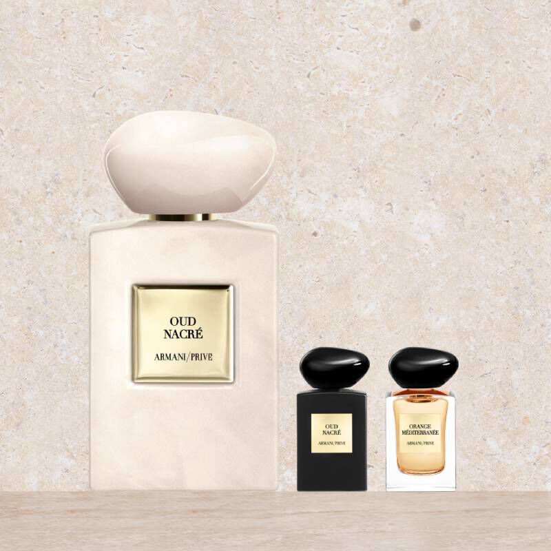 Drie Armani/Prive parfumflesjes: een grote parelmoerkleurige Oud Nacre en twee miniaturen (Oud Nacre en Orange Mediterranee).