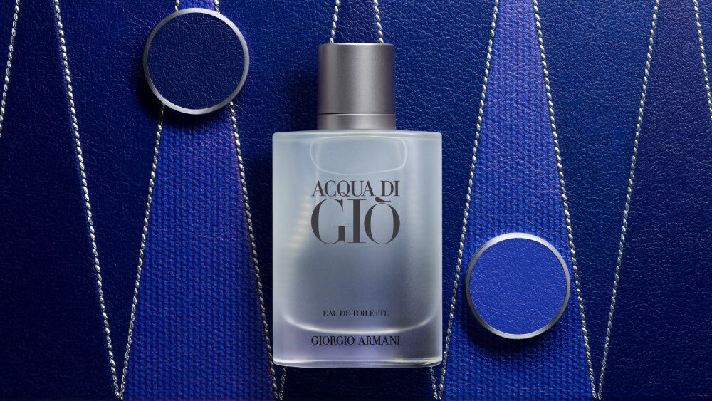 Armani ACQUA DI GIO EAU DE TOILETTE bottle displayed on a textured deep blue Blackgammon background with metallic accents, highlighting the fragrance’s modern, sophisticated, and aquatic identity. 