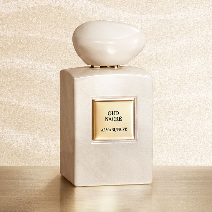 Armani/Prive Oud Nacre: een iriserende, parelmoerachtige flacon op een gouden voetstuk tegen een schitterende achtergrond. Een stralend eerbetoon aan de edele kostbaarheid van Oud en het vakmanschap van de haute parfumerie van het Huis Armani.