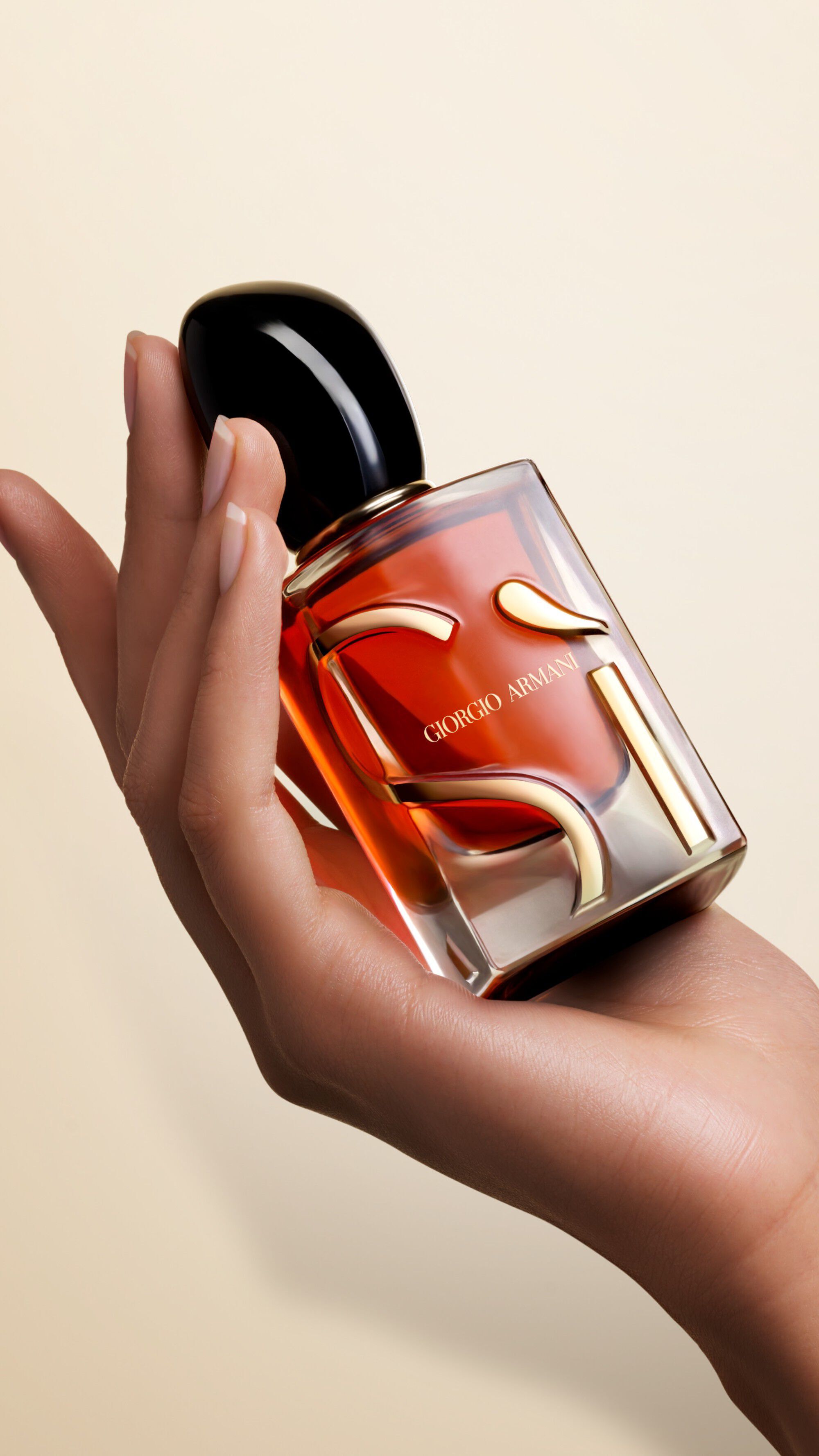 Een hand die een fles SI PARFUM vasthoudt