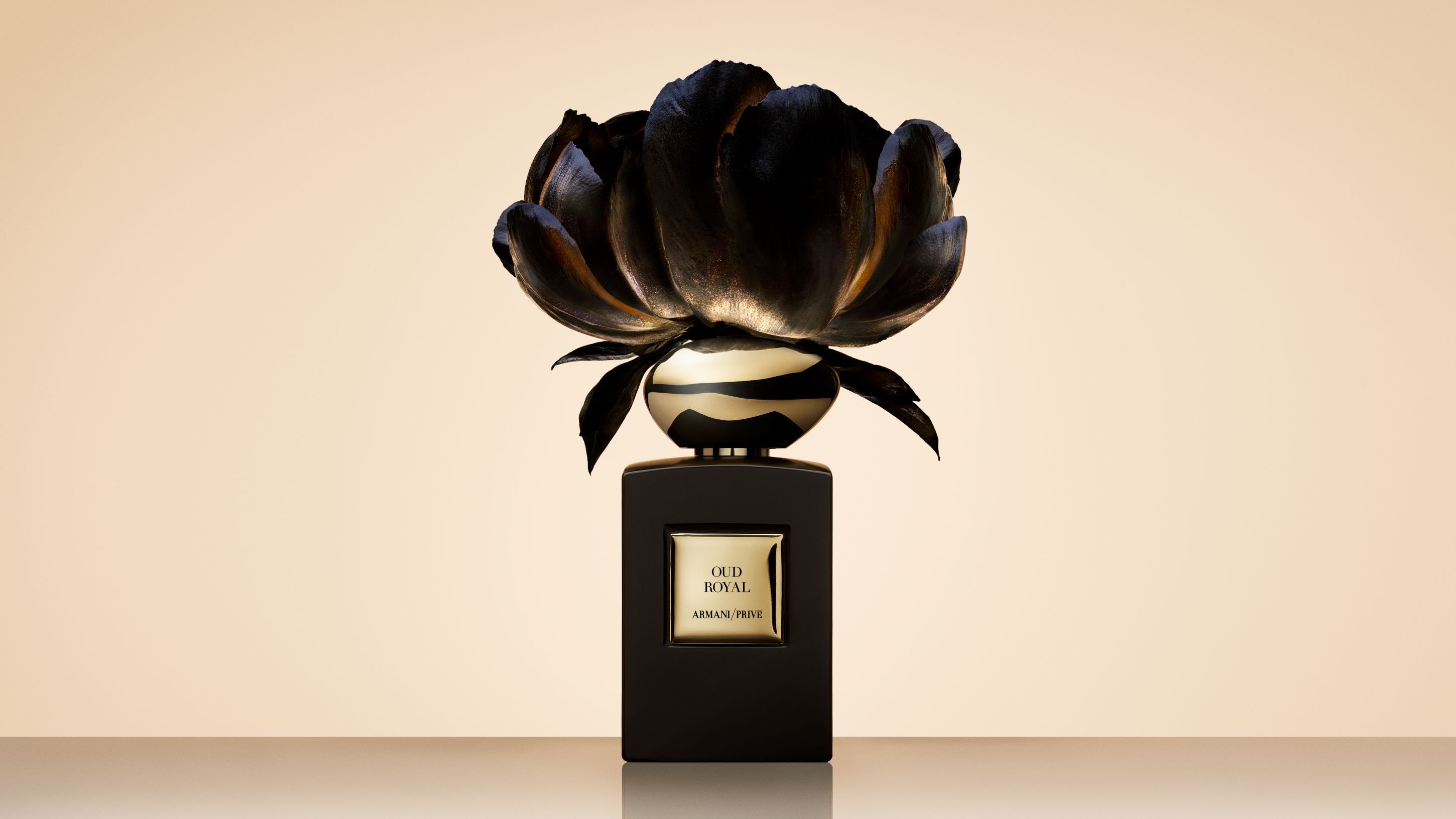 Armani/Prive Oud Royal parfumflacon bekroond met een grote, artistieke zwarte bloem.