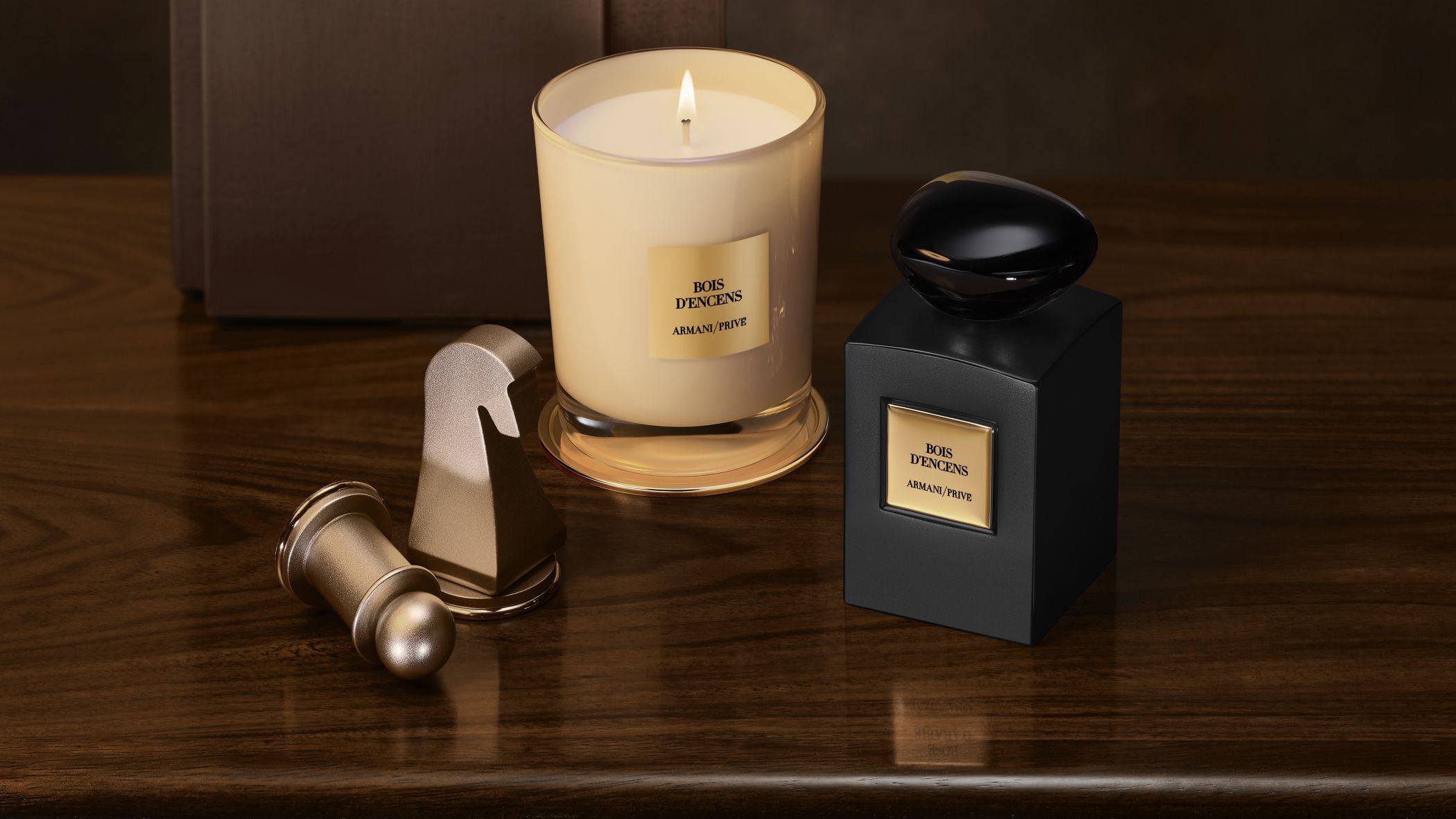Armani/Prive Bois d'Encens parfumflesje en brandende kaars naast schaakstukken op een houten tafel.