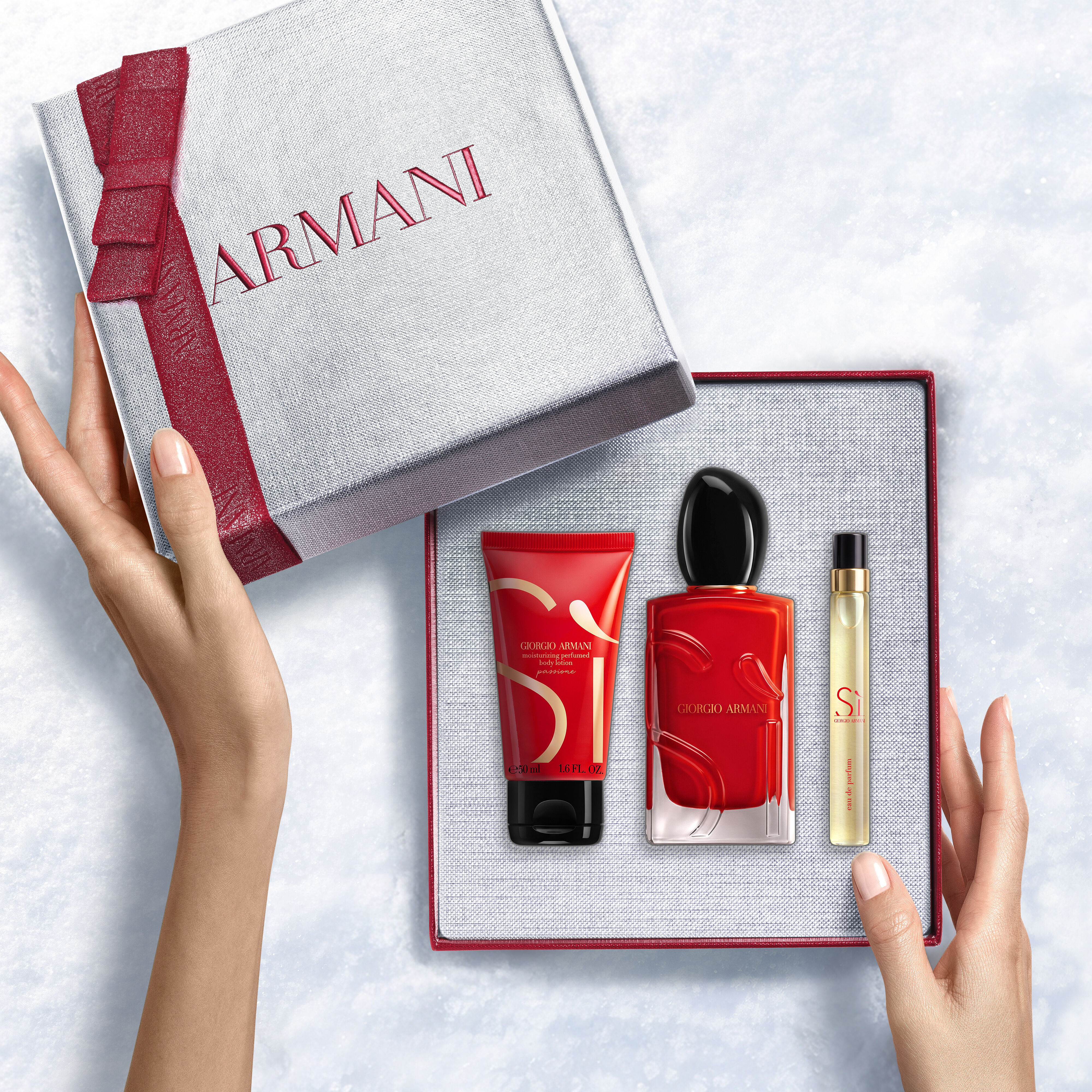 Hands onthullen een roodlint witte Armani cadeaubox met Si Passione Eau de Parfum 100ml, 10ml reismaat en 50ml Perfumed Body Lotion — een gedurfde bloemengeurset voor vrouwen — een gedurfde damesgeurset