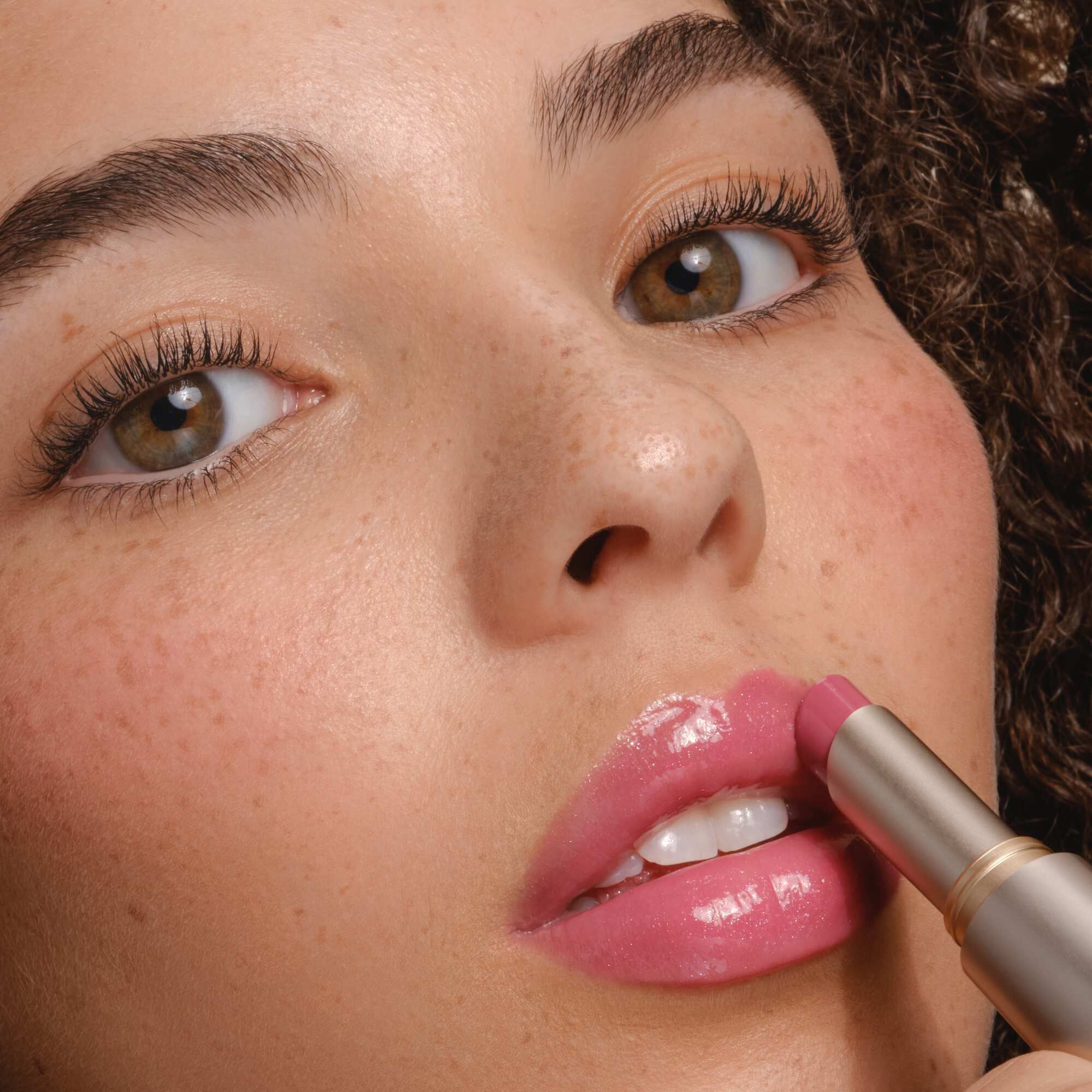 Armani Prisma Flash lippenstift aangebracht, met de nadruk op het strakke metallic ontwerp en de romige textuur van het product.