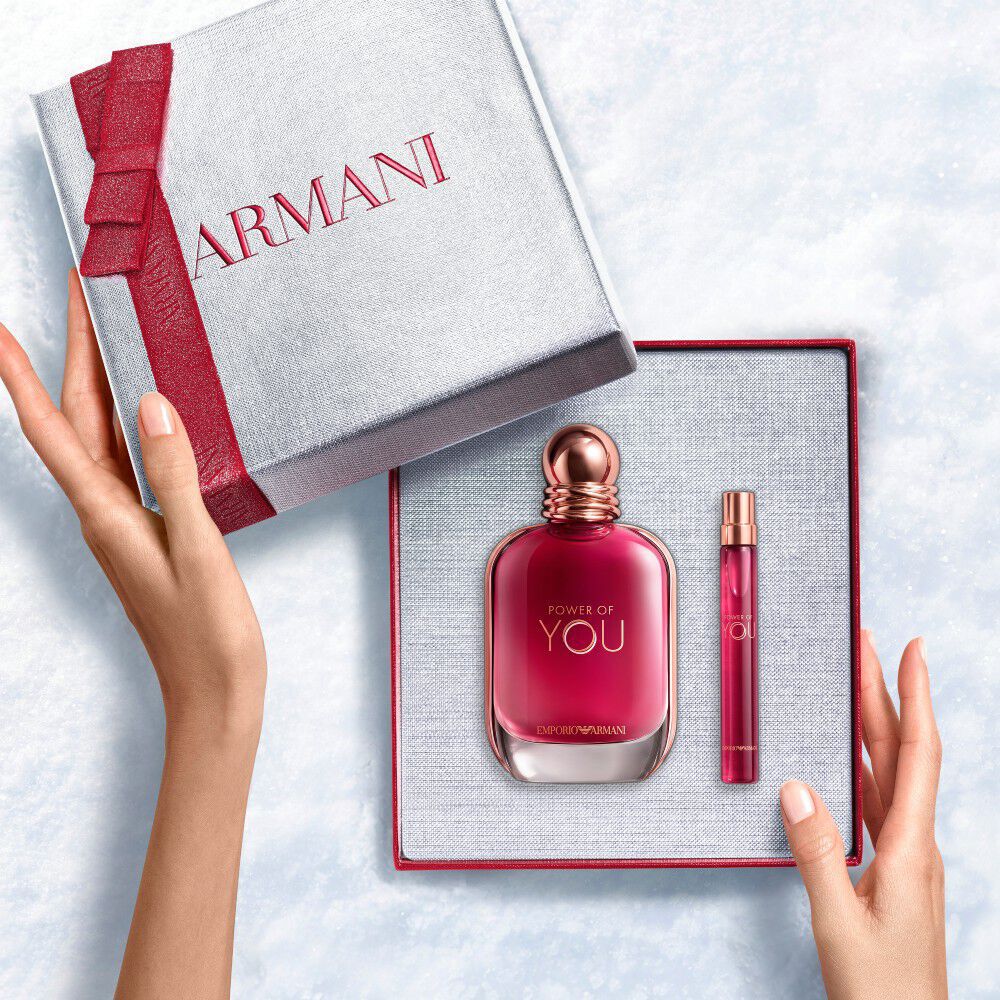 Hands onthullen een roodlint witte Armani cadeaudoos met Power of You Eau de Parfum 90 ml en 10 ml — een gedurfde, vrouwelijke geurset voor vrouwen.