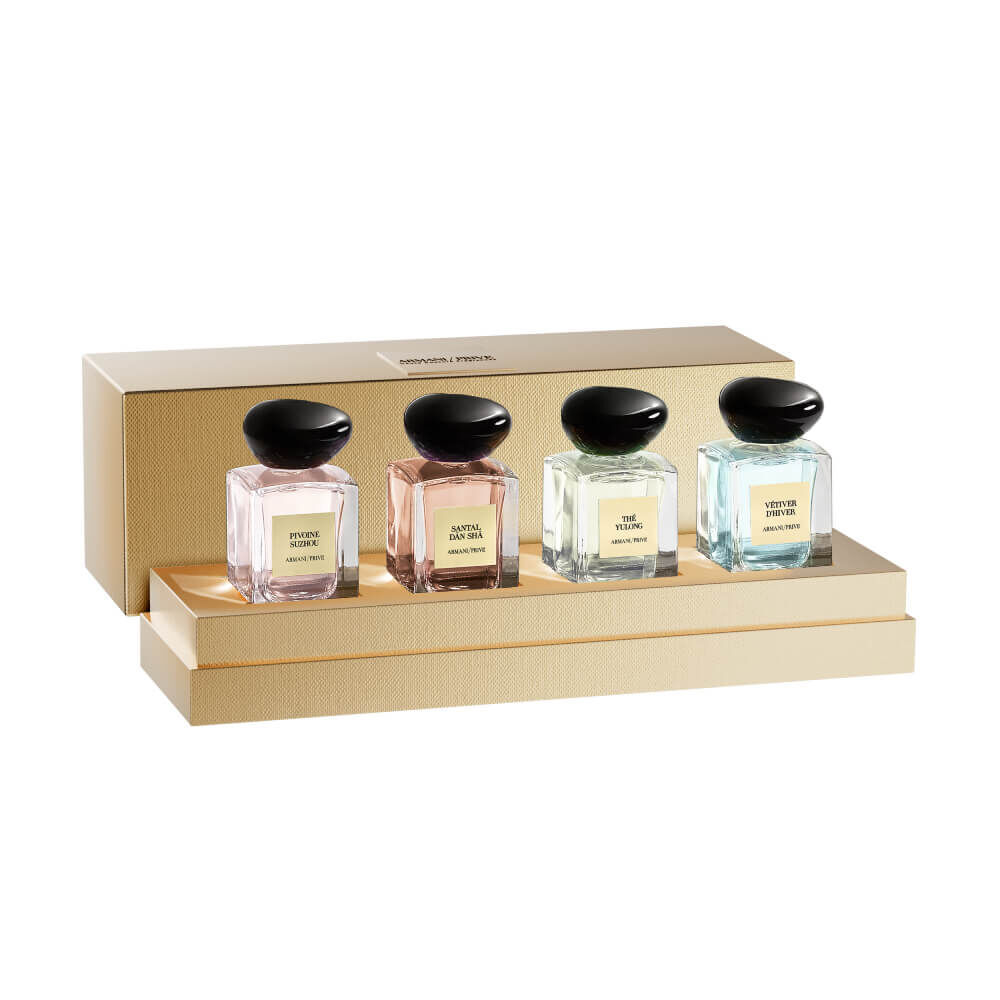 Four Armani Prive Les Eaux miniature eau de parfum bottles with black rounded caps displayed in a row on a white background: Pivoine Suzhou, The Yulong, Vetiver d'Hiver, and Santal Dān Shā.