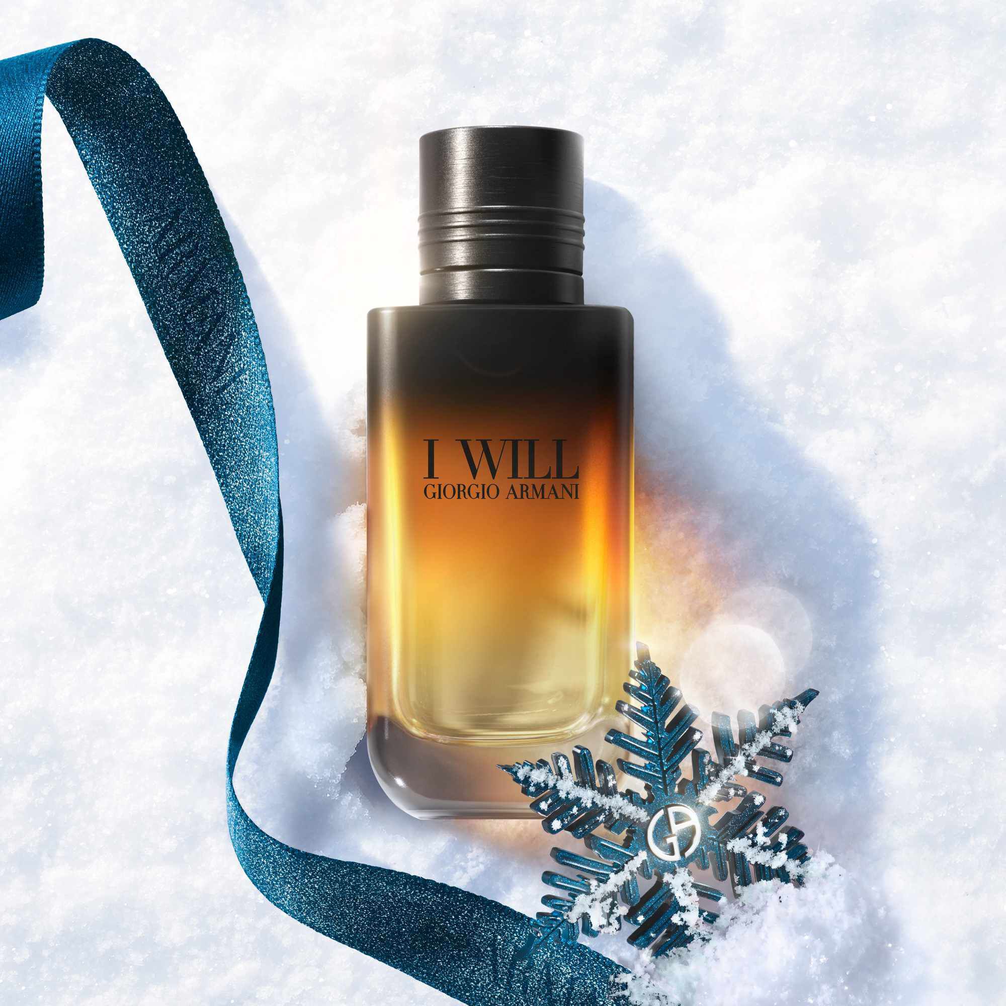 Zwarte en amber Armani cadeaudoos met turquoise lint op een besneeuwd oppervlak — I Will Eau de Parfum herengeur-cadeauset, feestcadeau-visual.