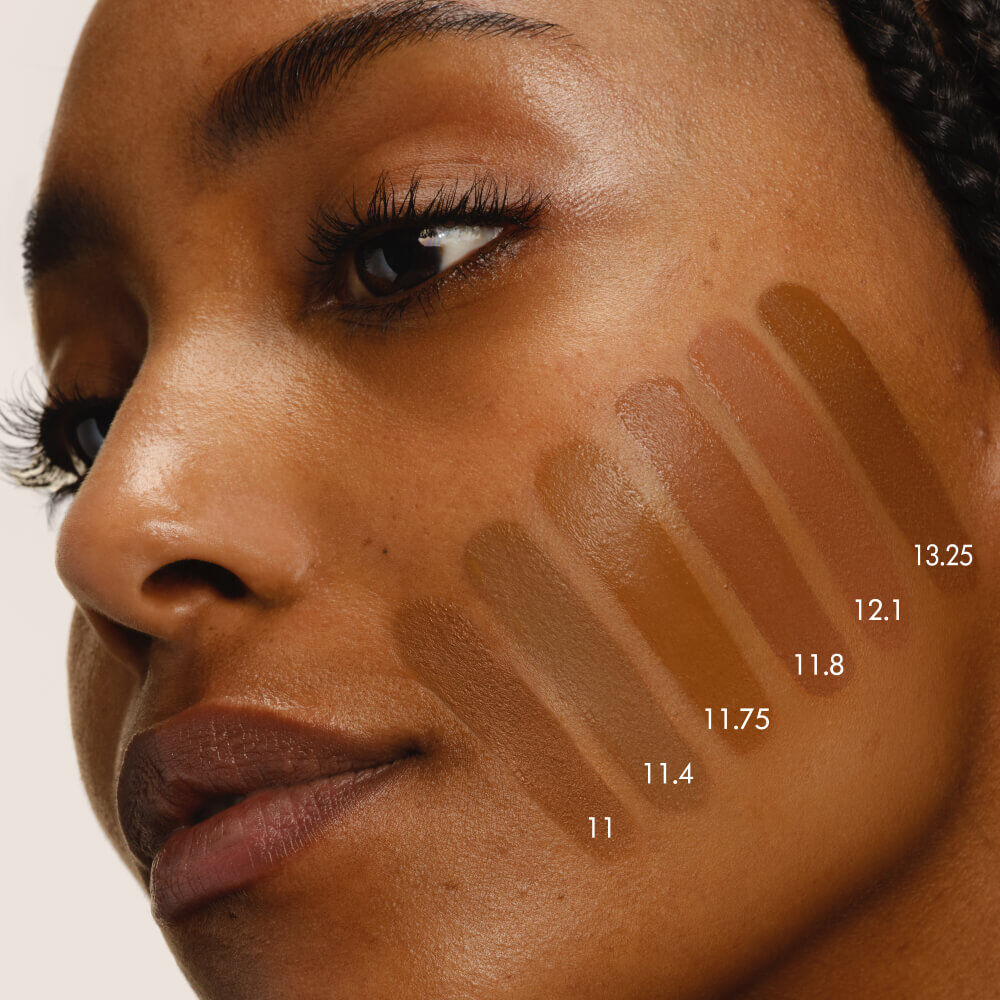 Close-up of a model's cheek with five swatches of LUMINOUS SILK FOUNDATION in shades