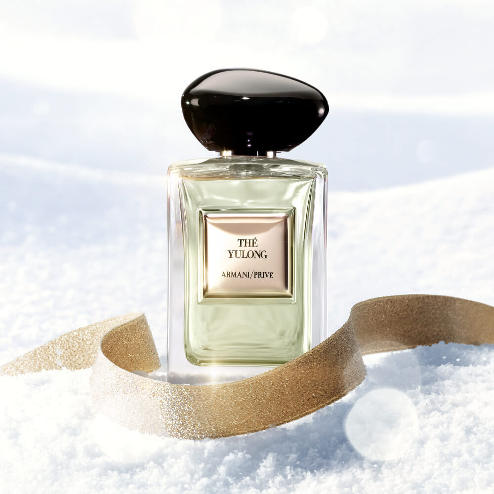 Armani Prive Les Eaux The Yulong Holiday gift set, open gold box on a warm background revealing the eau de parfum bottle, miniature fragrance and Scented soap nestled inside.