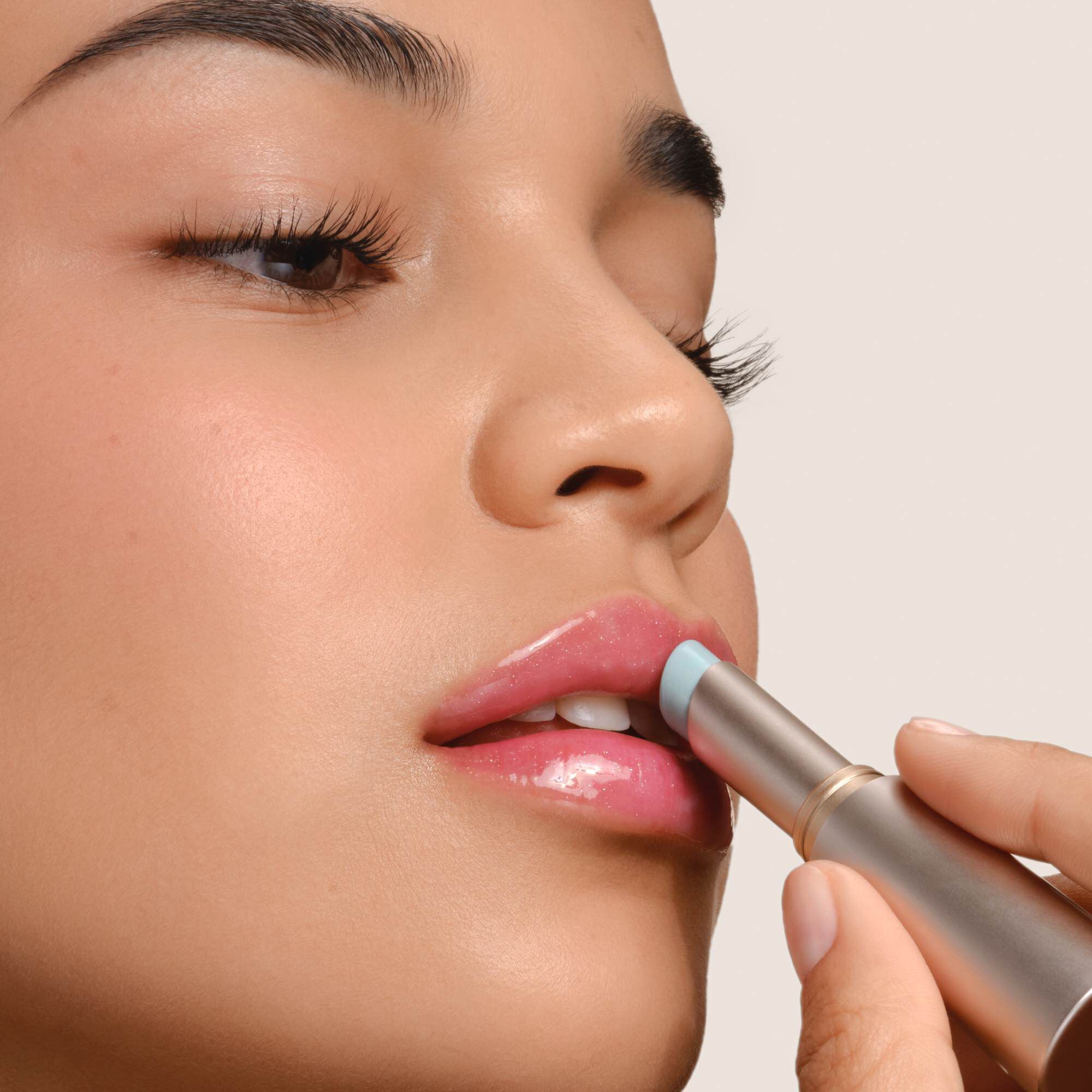 Armani Prisma Flash lippenstift aangebracht, met de nadruk op het strakke metallic ontwerp en de romige textuur van het product.