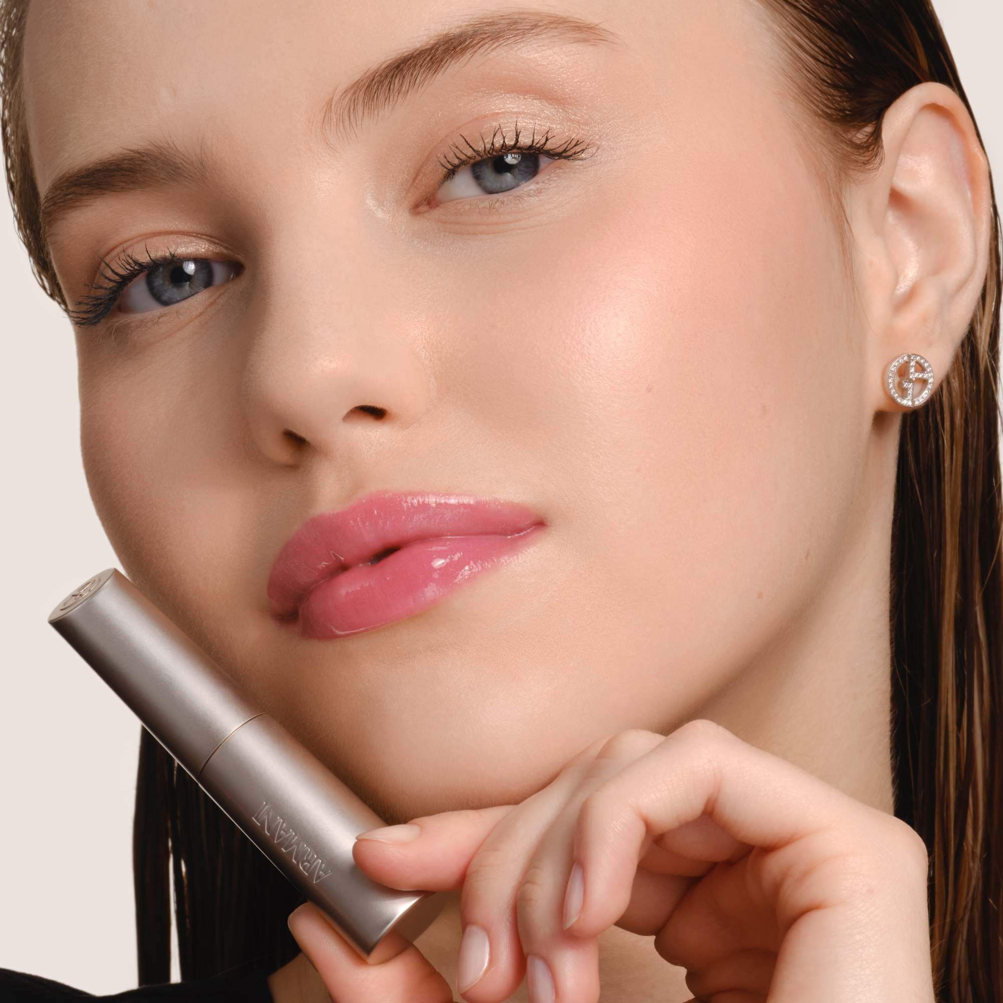 Armani Prisma Flash lippenstift aangebracht, met de nadruk op het strakke metallic ontwerp en de romige textuur van het product.