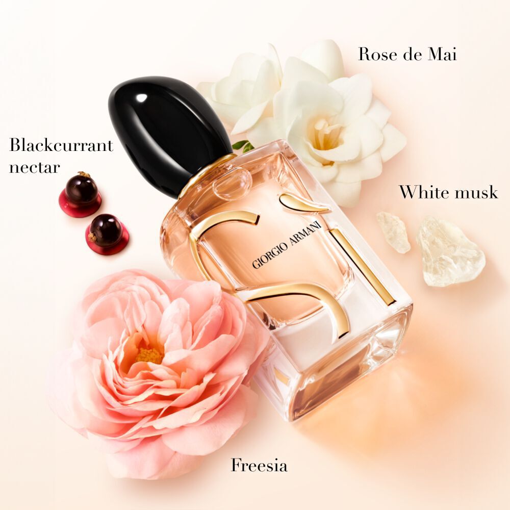 Si Eau de Parfum fles omringd door rose de mai, zwarte bessen, freesia en witte muskusingredienten bloeit op een zachte blush-achtergrond — Giorgio Armani visueel de vrouwengeur-key notes key notes.