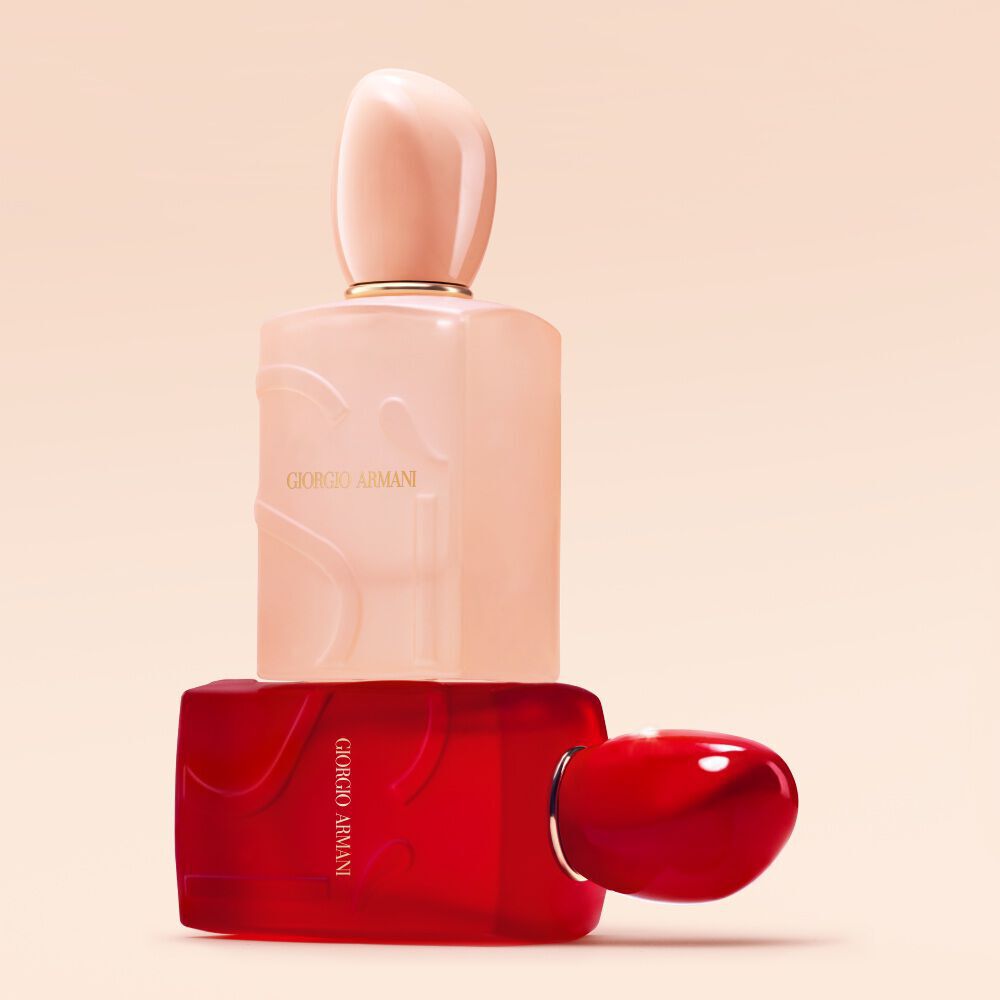 Giorgio Armani Si Nude Bloom en Si Passione Red Bloom flessen opgestapeld op een naakte achtergrond.