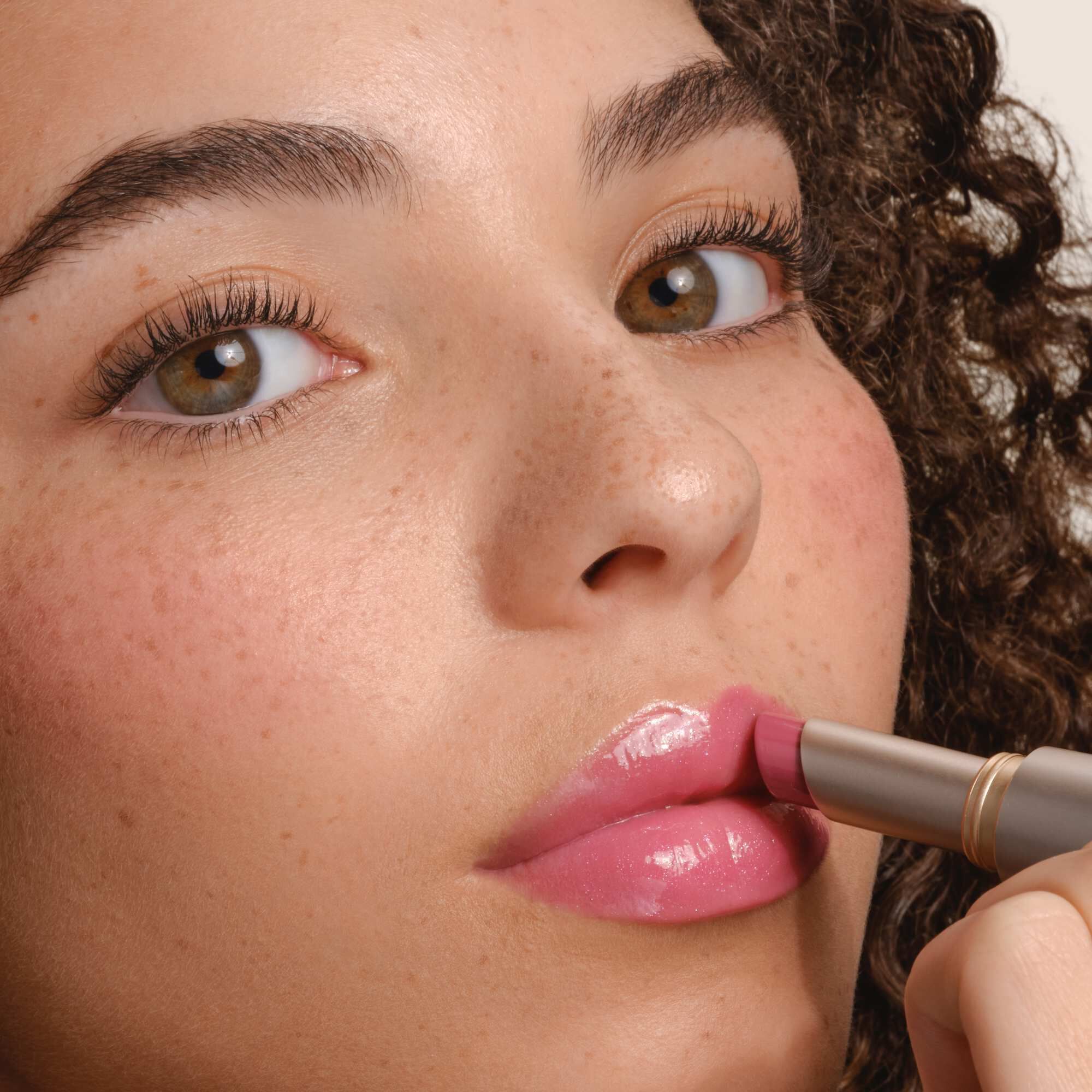 Armani Prisma Flash lippenstift aangebracht, met de nadruk op het strakke metallic ontwerp en de romige textuur van het product.