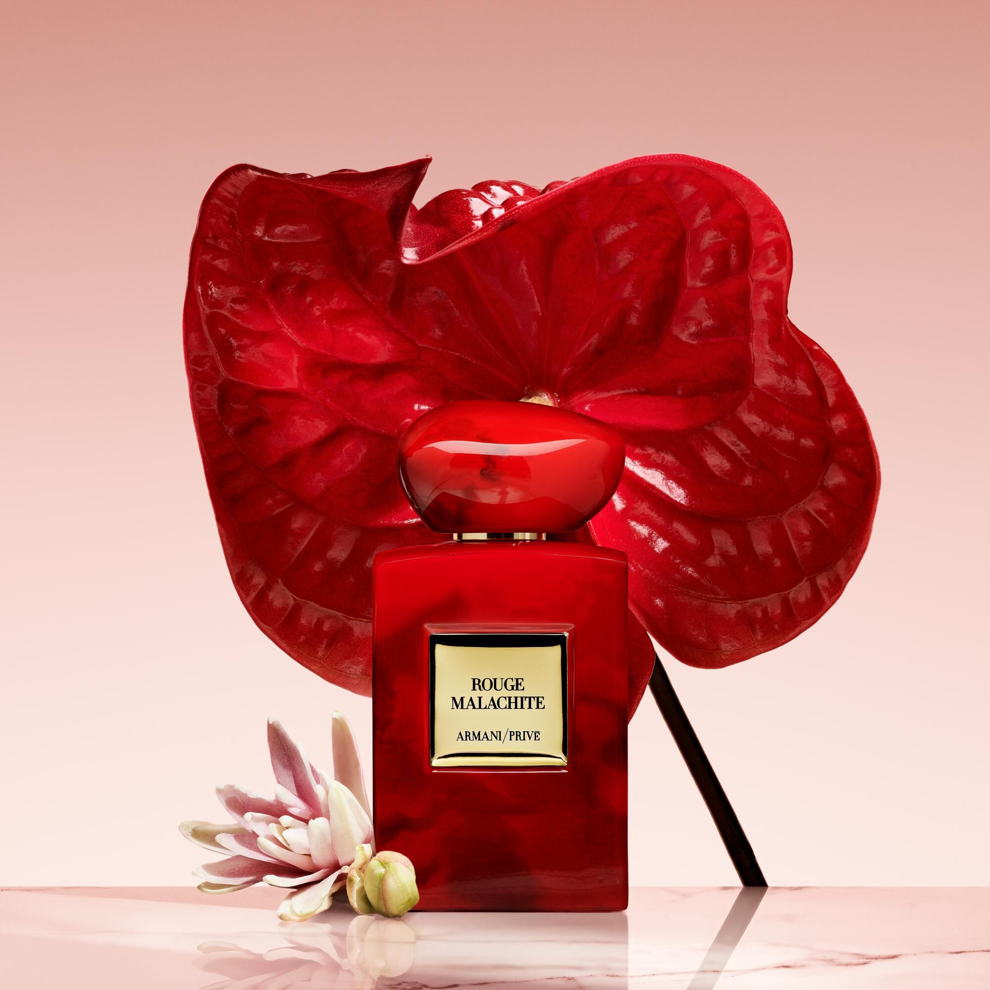 Armani/Prive Rouge Malachite: opvallende rode fles tegen een levendige anthurium en tere bloemen, die de intense aantrekkingskracht van de geur weerspiegelen.