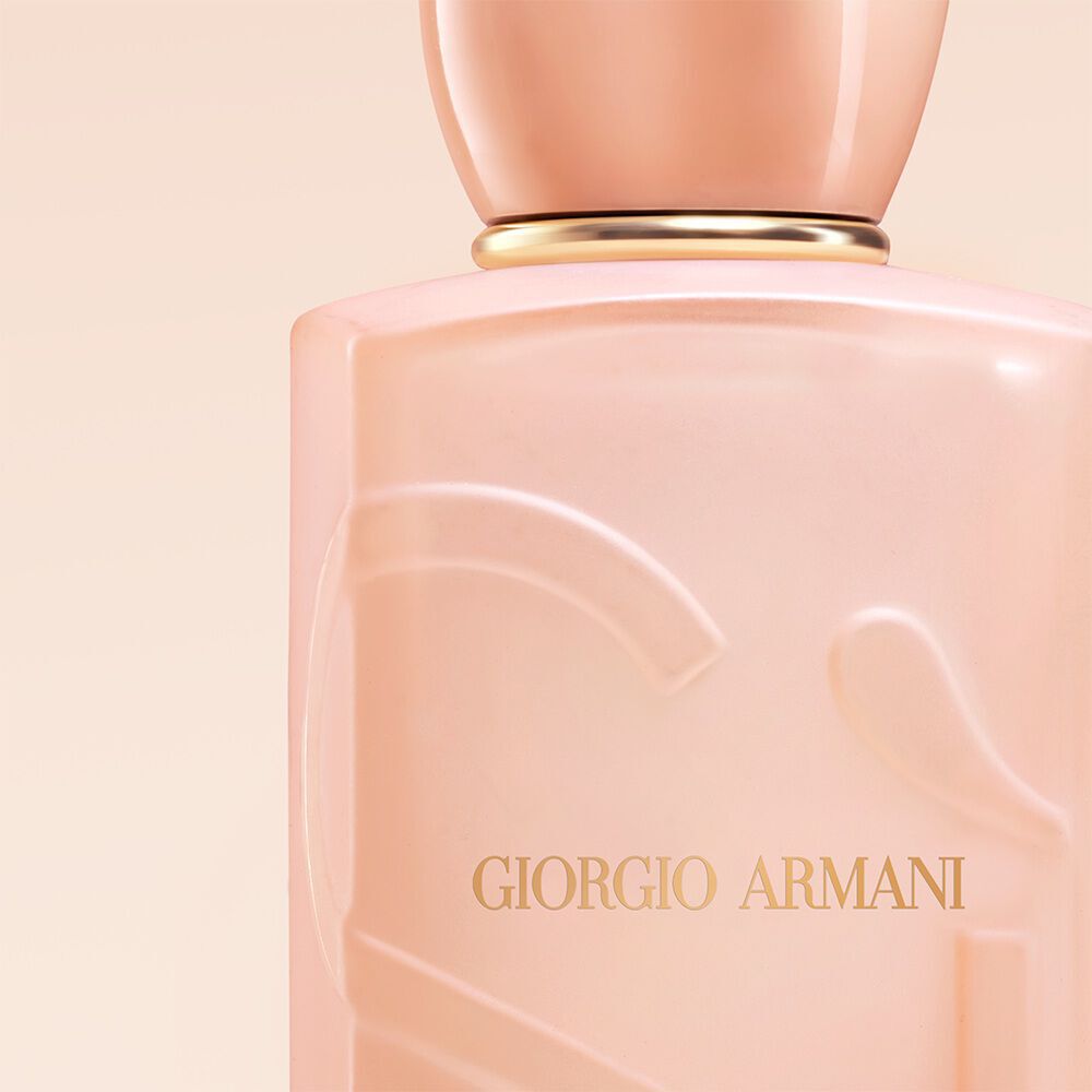 Giorgio Armani Si Nude Bloom parfum dichtbij op de fles op een naakte achtergrond.