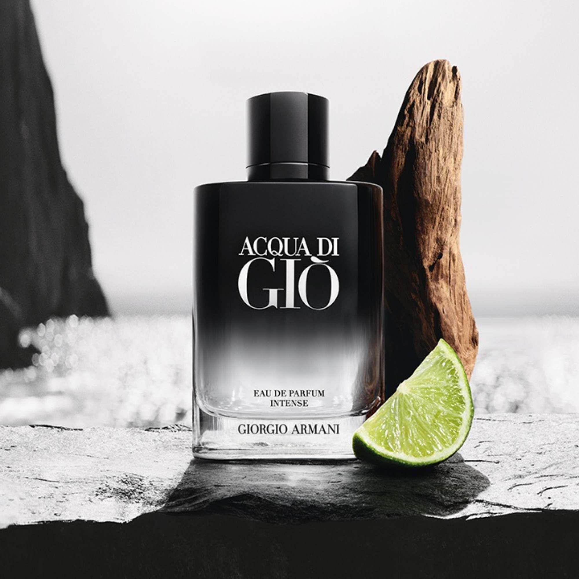 Giorgio Armani Acqua Di Gio Eau de Parfum Intense fles aan zee met drijfhout en kalk.