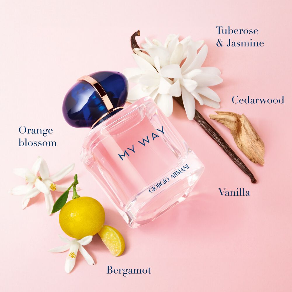 My Way Eau de Parfum van Giorgio Armani, blushroze fles omringd door oranjebloesem, bergamot, tuberoos, jasmijn, vanille en cederhout op een zachte roze achtergrond — bloemengeur voor vrouwen.
