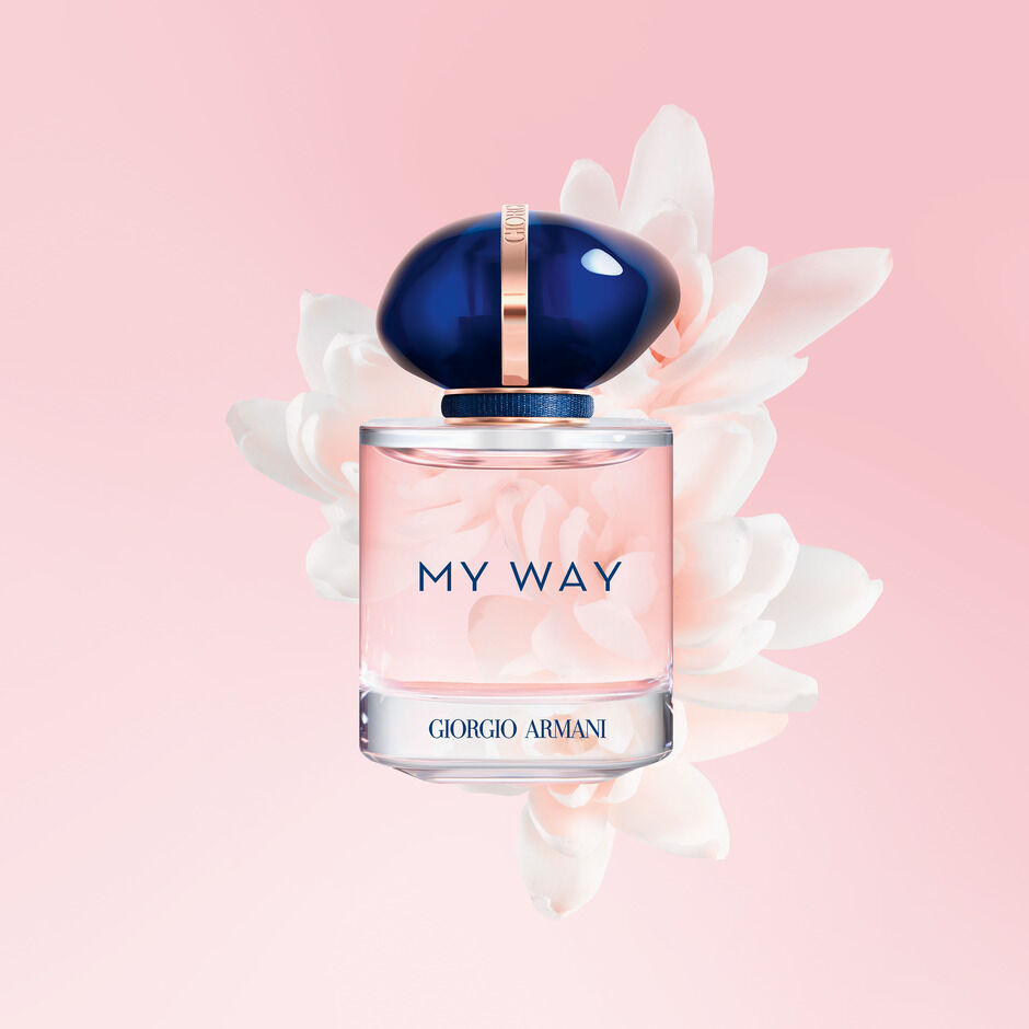 Parfumfles van Giorgio Armani 'My Way' met een blauwe dop, omringd door zachte bloemen op een roze achtergrond.