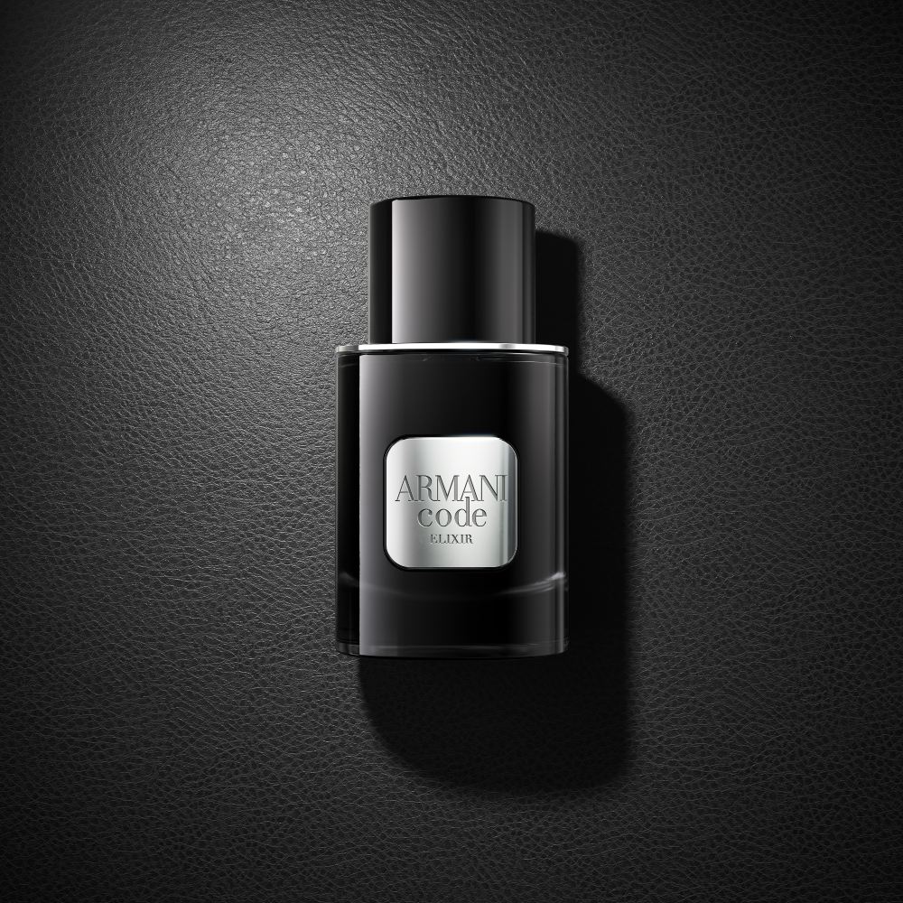 Een zwart flesje Armani Code Elixir parfum rust elegant op een bijpassend zwart oppervlak en creëert een geraffineerde monochrome look.
